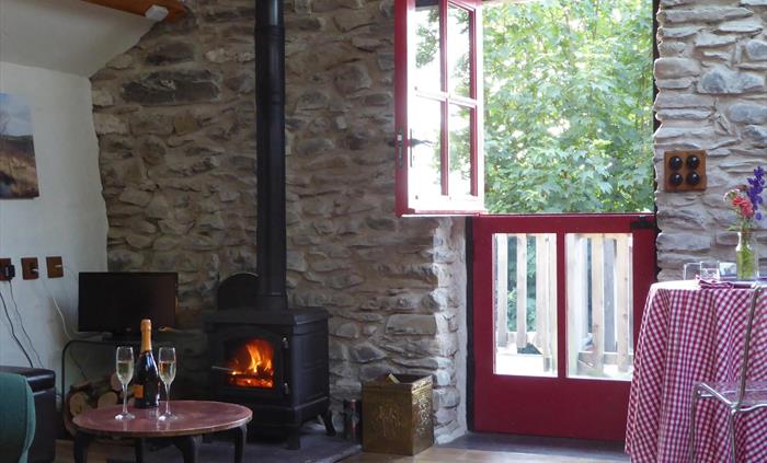 Relax with a glass of bubbly in front of a wood burning stove fire, stable door open